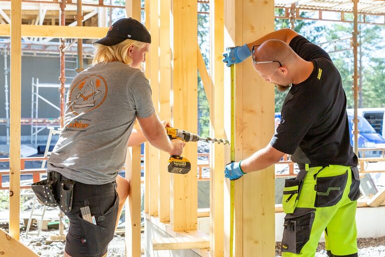 Azubi macht Praktikum bei finnischen Handwerksbetrieb und arbeitet auf einer Baustelle an einer Holzkonstruktion