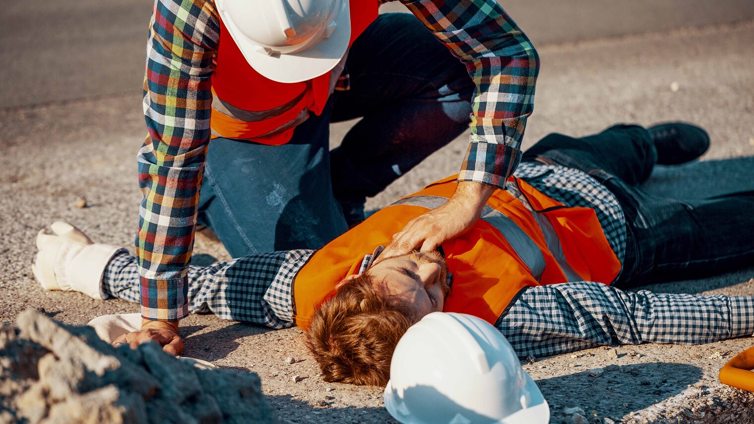 Symbolfoto: Ein Handwerker hilft einem anderen bewusstlosen Handwerker